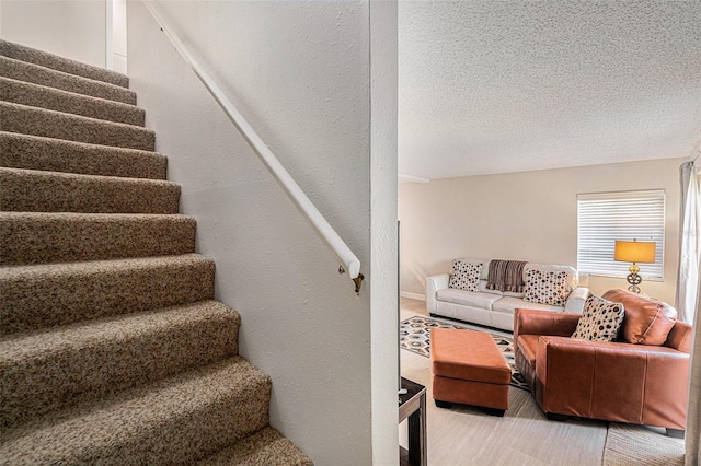 stairs featuring a textured ceiling and a textured wall