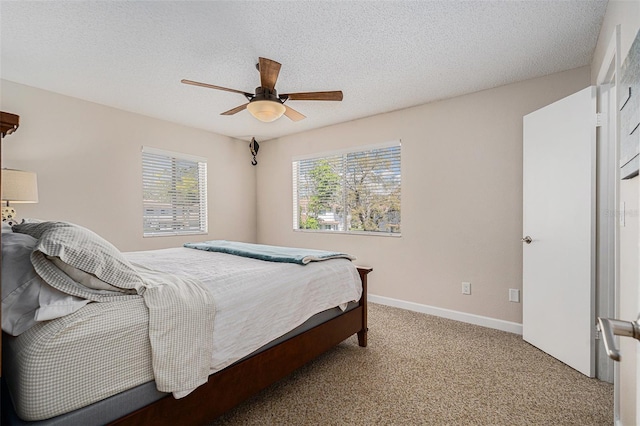 carpeted bedroom featuring a textured ceiling, ceiling fan, and baseboards