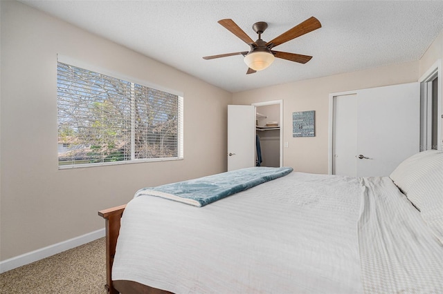 bedroom featuring carpet floors, ceiling fan, baseboards, and a textured ceiling