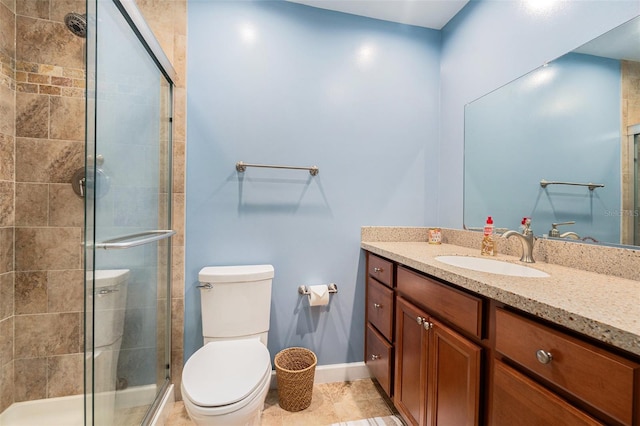 bathroom with toilet, a shower stall, vanity, tile patterned flooring, and baseboards