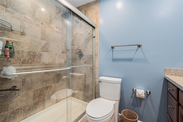 full bathroom featuring a shower stall, vanity, and toilet