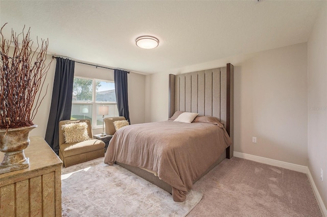 bedroom with baseboards and light colored carpet