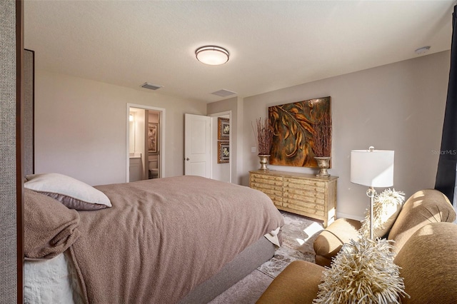 bedroom with visible vents and ensuite bath