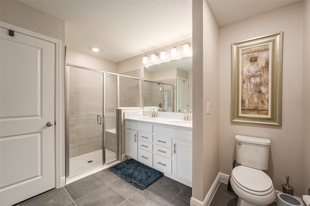 full bathroom with toilet, a stall shower, double vanity, and a sink