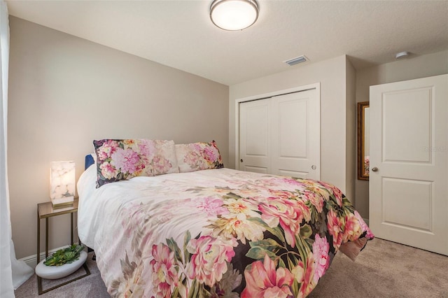 bedroom featuring a closet, visible vents, and light carpet