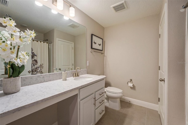 bathroom featuring baseboards, vanity, visible vents, and tile patterned floors