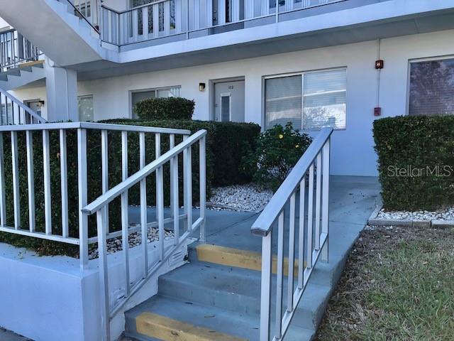 property entrance featuring a balcony and stucco siding