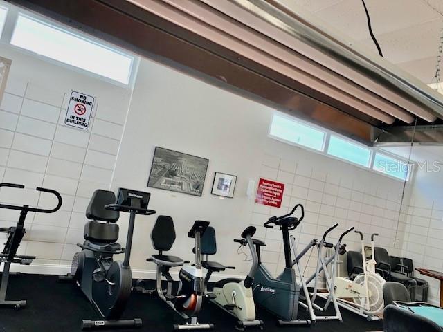 exercise room with a wealth of natural light and tile walls