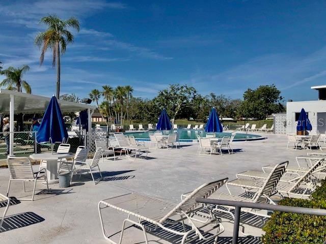 view of patio / terrace with fence and a community pool