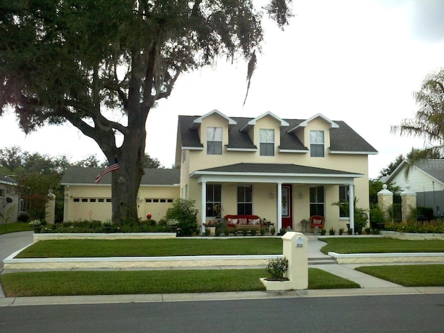 view of front of house with a front lawn, a porch, and a garage