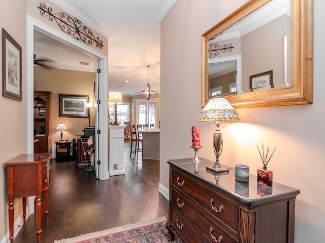 hall with dark wood-style flooring and crown molding