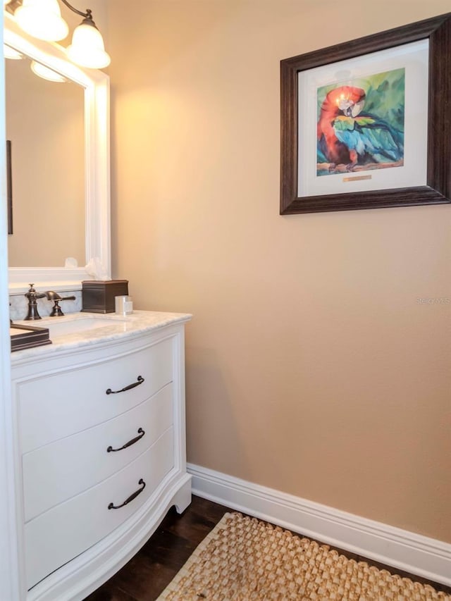 bathroom featuring vanity, baseboards, and wood finished floors