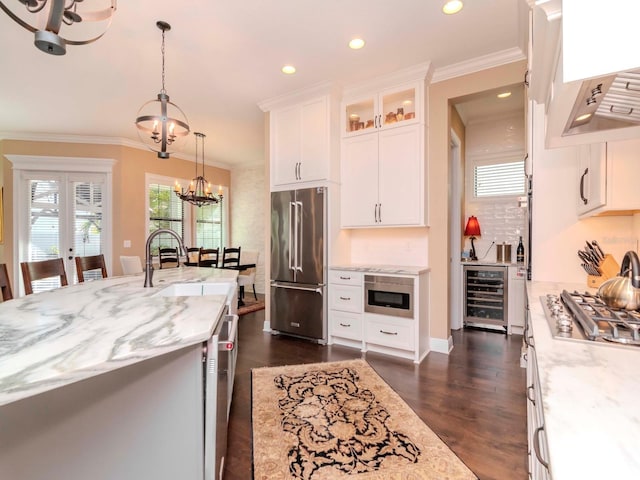 kitchen featuring wine cooler, appliances with stainless steel finishes, glass insert cabinets, white cabinets, and a chandelier