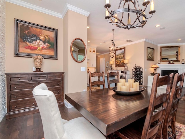 dining area featuring visible vents, dark wood finished floors, ornamental molding, an inviting chandelier, and a fireplace