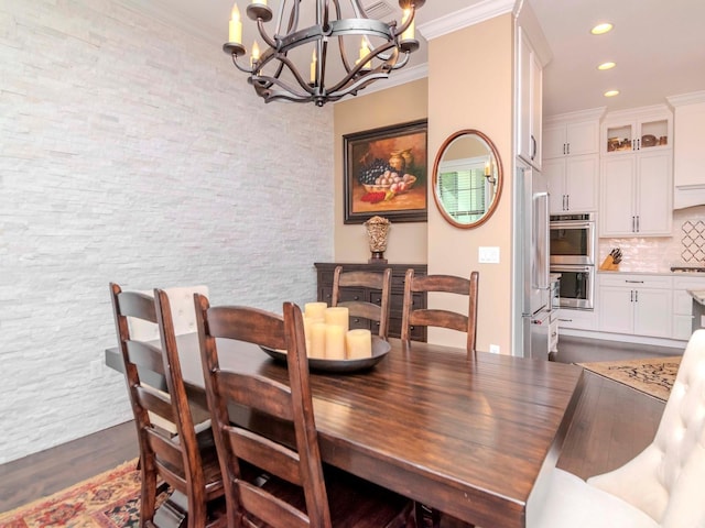 dining space with ornamental molding, recessed lighting, a chandelier, and wood finished floors