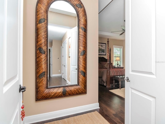 hall with dark wood-style floors and baseboards