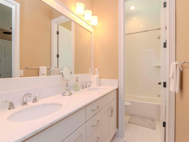 full bath with double vanity, a sink, toilet, and tile patterned floors