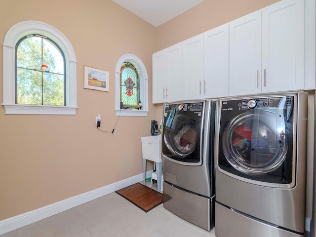 laundry room featuring cabinet space, washer and clothes dryer, and baseboards