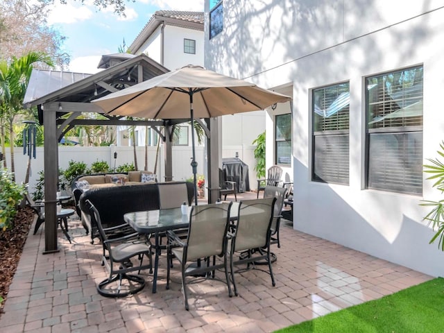 view of patio / terrace with outdoor dining space, a fenced backyard, a gazebo, and an outdoor hangout area