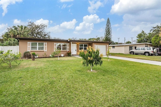 ranch-style home featuring an attached garage, driveway, a front yard, and fence