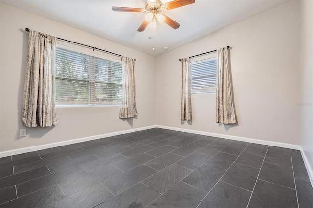 spare room featuring ceiling fan and baseboards