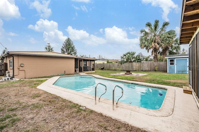 view of swimming pool with a fenced in pool, an outbuilding, a lawn, a shed, and a fenced backyard