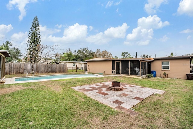 back of property featuring a fenced backyard, a fire pit, a sunroom, a lawn, and a fenced in pool