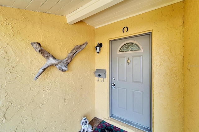 entrance to property featuring stucco siding