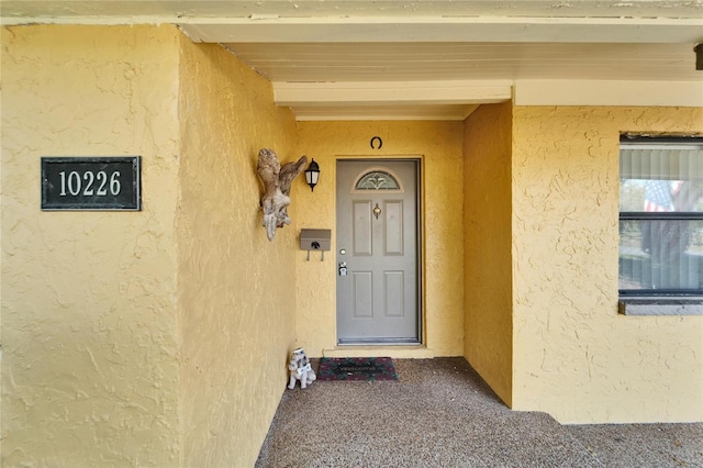 entrance to property with stucco siding