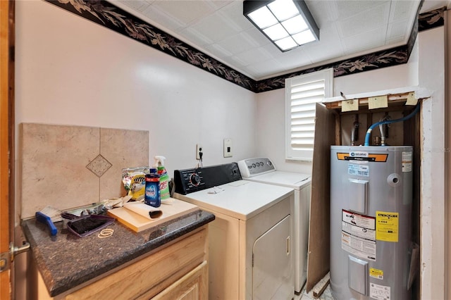 washroom with laundry area, washer and clothes dryer, and electric water heater