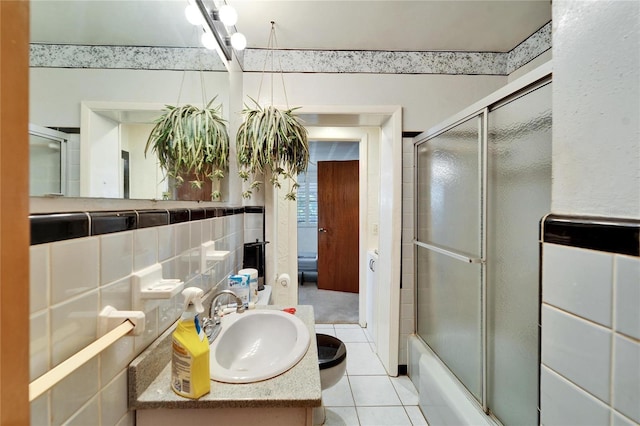 full bathroom with bath / shower combo with glass door, tile patterned floors, tile walls, vanity, and decorative backsplash