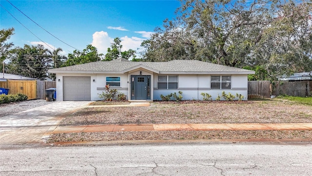 single story home featuring a garage, decorative driveway, fence, and stucco siding