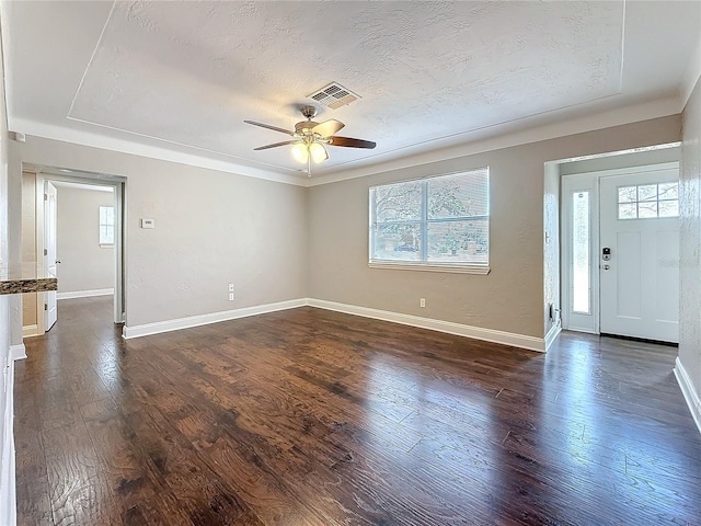 entrance foyer featuring ceiling fan, a textured ceiling, visible vents, baseboards, and dark wood-style floors