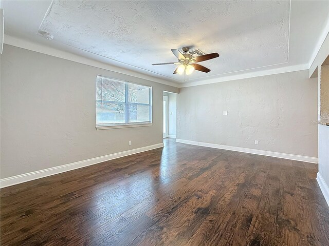 spare room featuring dark wood-type flooring, a textured ceiling, and baseboards