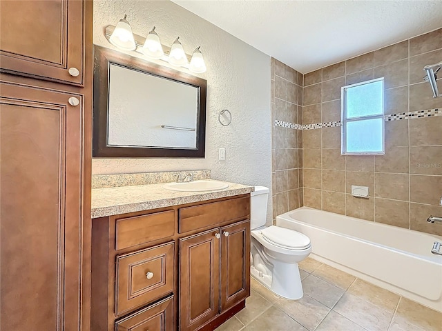 bathroom featuring bathtub / shower combination, a textured wall, toilet, vanity, and tile patterned flooring