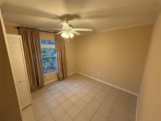 spare room featuring ceiling fan, ornamental molding, and baseboards