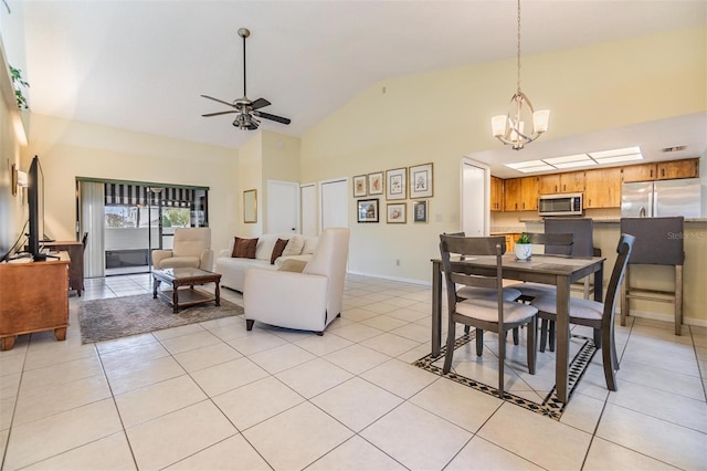 dining space featuring high vaulted ceiling, ceiling fan with notable chandelier, baseboards, and light tile patterned floors