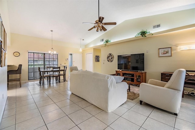 living area with light tile patterned floors, visible vents, high vaulted ceiling, and ceiling fan with notable chandelier