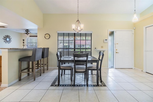 tiled dining room with ceiling fan with notable chandelier and baseboards