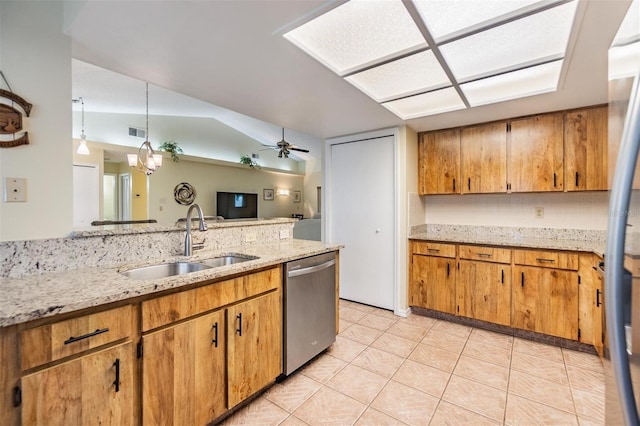 kitchen with light tile patterned floors, appliances with stainless steel finishes, brown cabinetry, and a sink