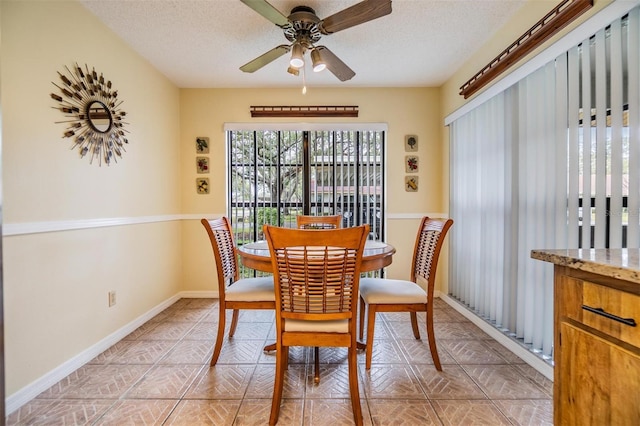 dining area featuring a ceiling fan, baseboards, and a textured ceiling