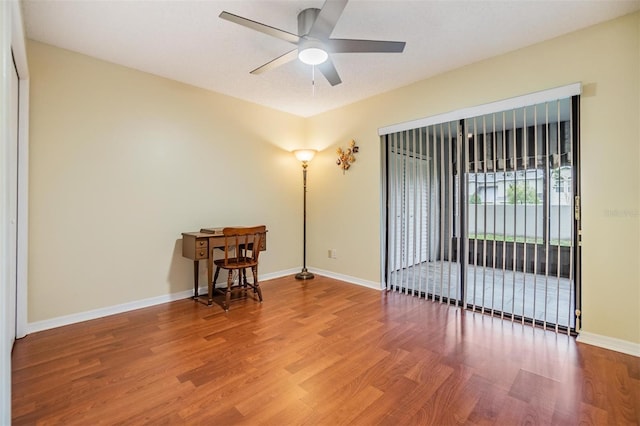 unfurnished room featuring a ceiling fan, baseboards, and wood finished floors