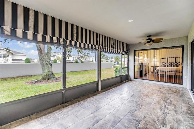 unfurnished sunroom featuring ceiling fan