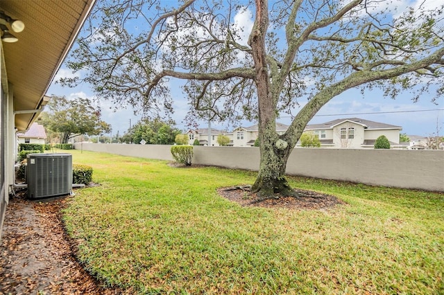 view of yard with fence and central AC unit