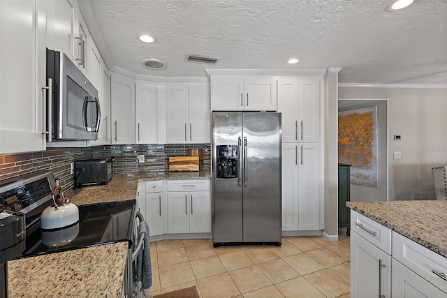 kitchen featuring white cabinetry, visible vents, appliances with stainless steel finishes, and light stone counters