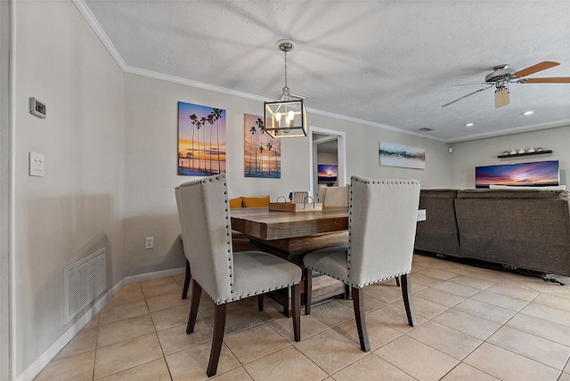 dining space featuring crown molding, light tile patterned floors, visible vents, a textured ceiling, and baseboards