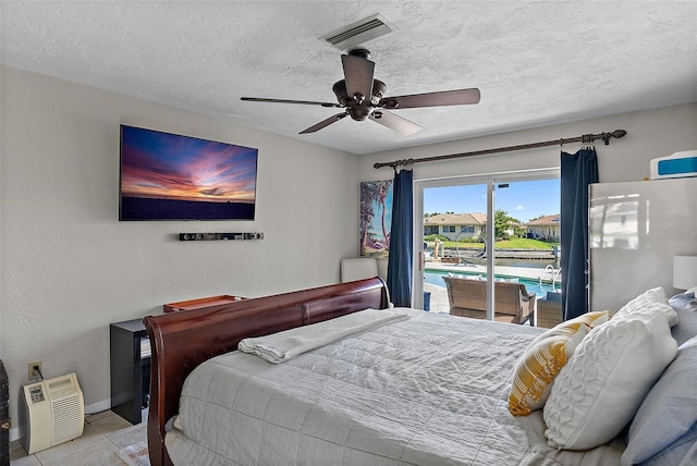 bedroom with light tile patterned floors, a textured ceiling, ceiling fan, visible vents, and access to outside