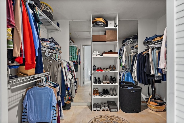 spacious closet with attic access and light tile patterned flooring