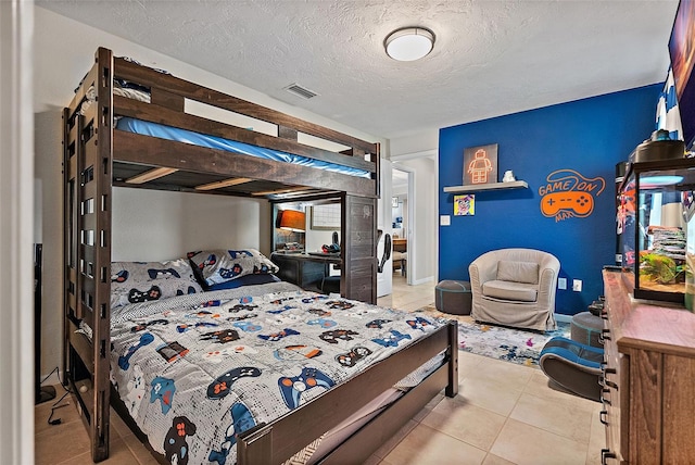 bedroom featuring visible vents, a textured ceiling, and light tile patterned flooring