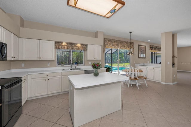 kitchen featuring light tile patterned floors, white cabinets, light countertops, black appliances, and a sink